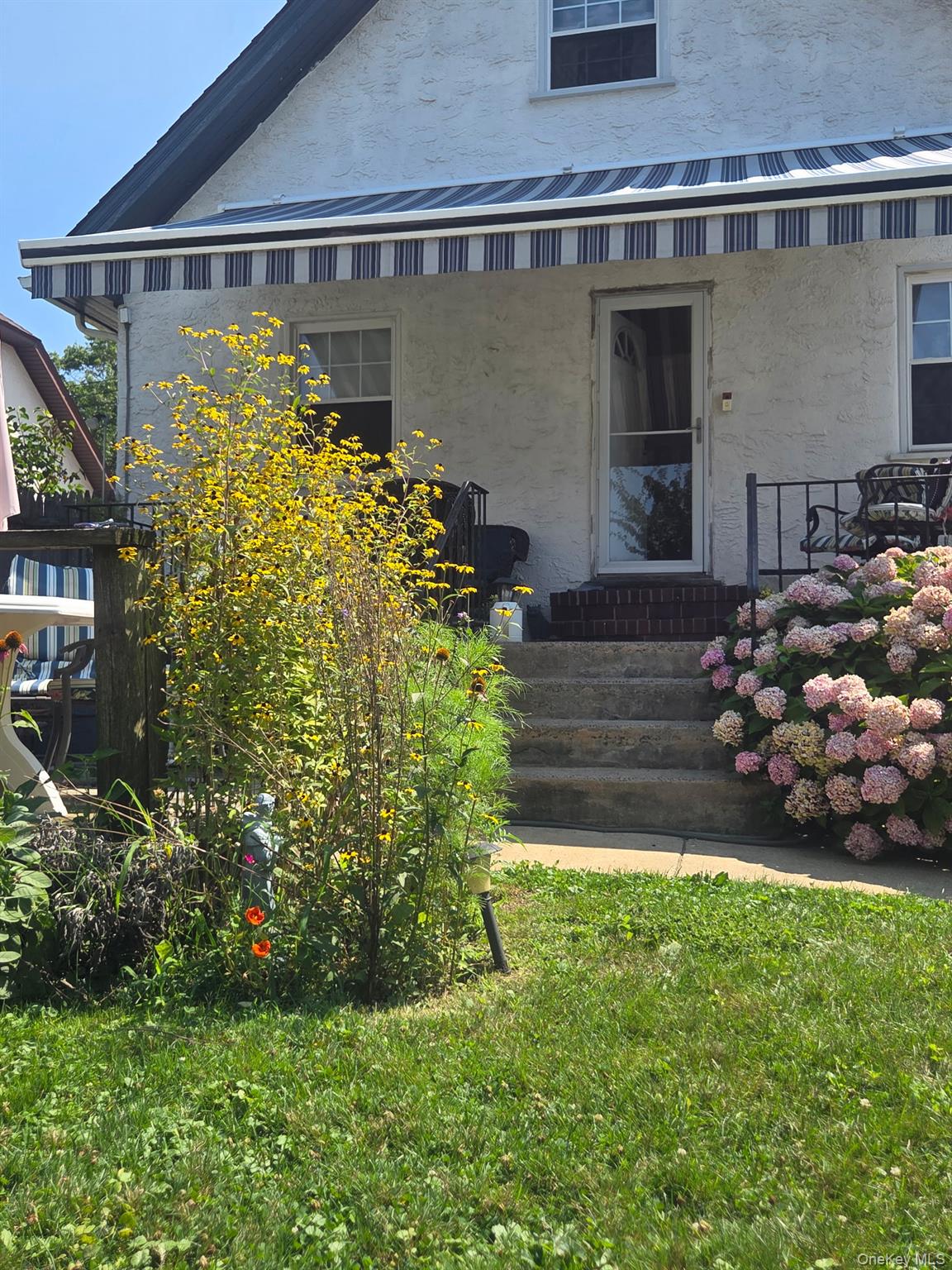 80 Dobson Avenue Merrick, NY 11566 - Photo 4 of 21 a front view of a house with garden