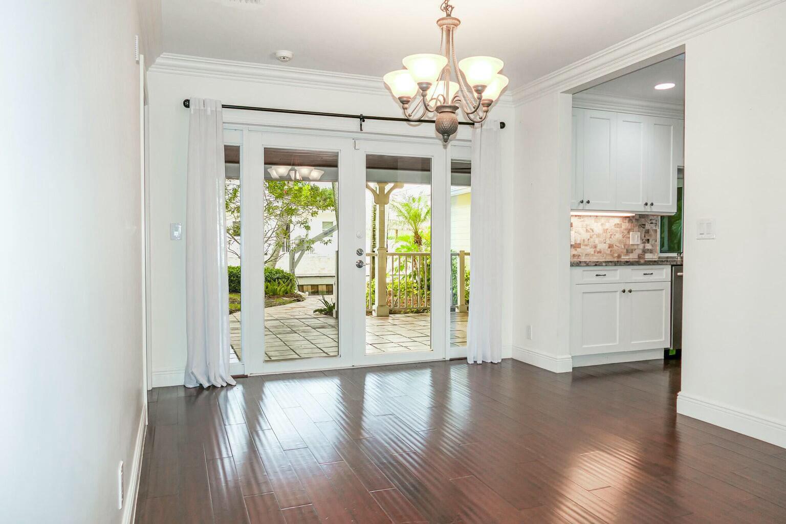 18014 Perigon Way Jupiter, FL 33458 - Photo 8 of 35 a view of a big room with wooden floor chandelier and windows