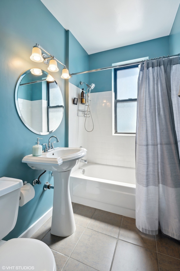 725 West Sheridan Road, Unit 603 Chicago, IL 60613 - Photo 12 of 16 a bathroom with a sink and mirror with bathtub