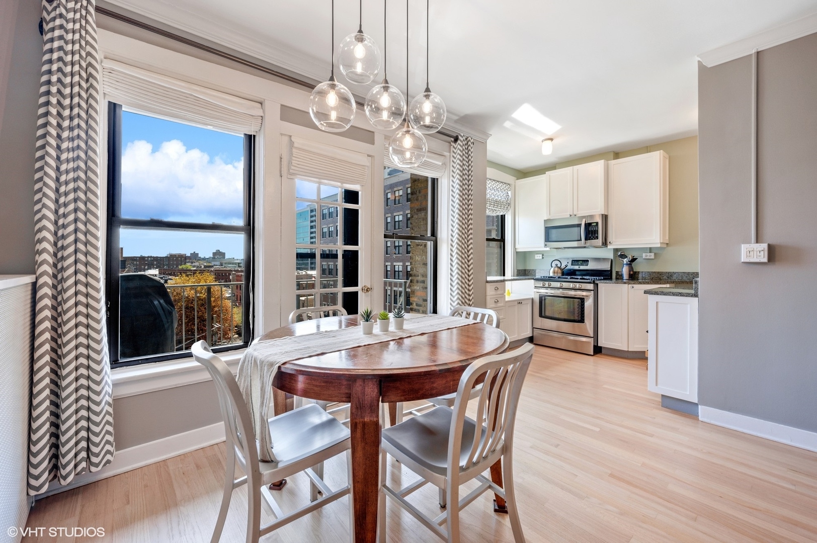 725 West Sheridan Road, Unit 603 Chicago, IL 60613 - Photo 6 of 16 a dining room with furniture a chandelier and kitchen view