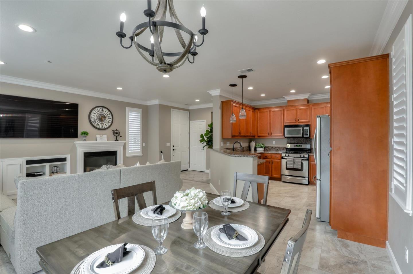 7820 Dickens Way Gilroy, CA 95020 - Photo 11 of 27 a open dining room with furniture a kitchen and chandelier