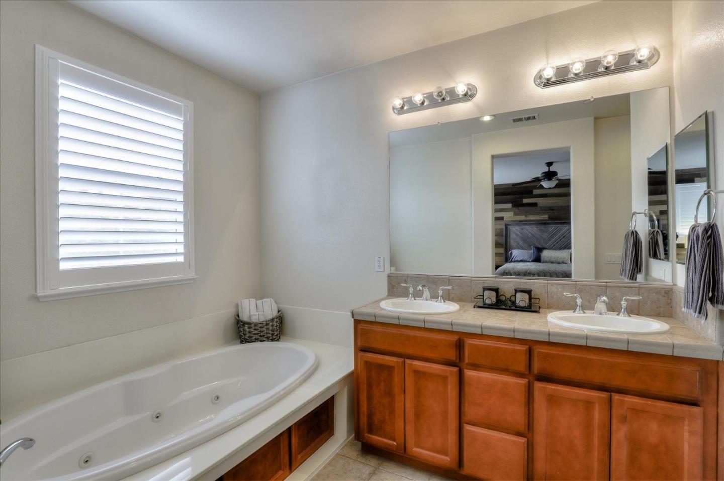 7820 Dickens Way Gilroy, CA 95020 - Photo 17 of 27 a bathroom with a tub sink and mirror
