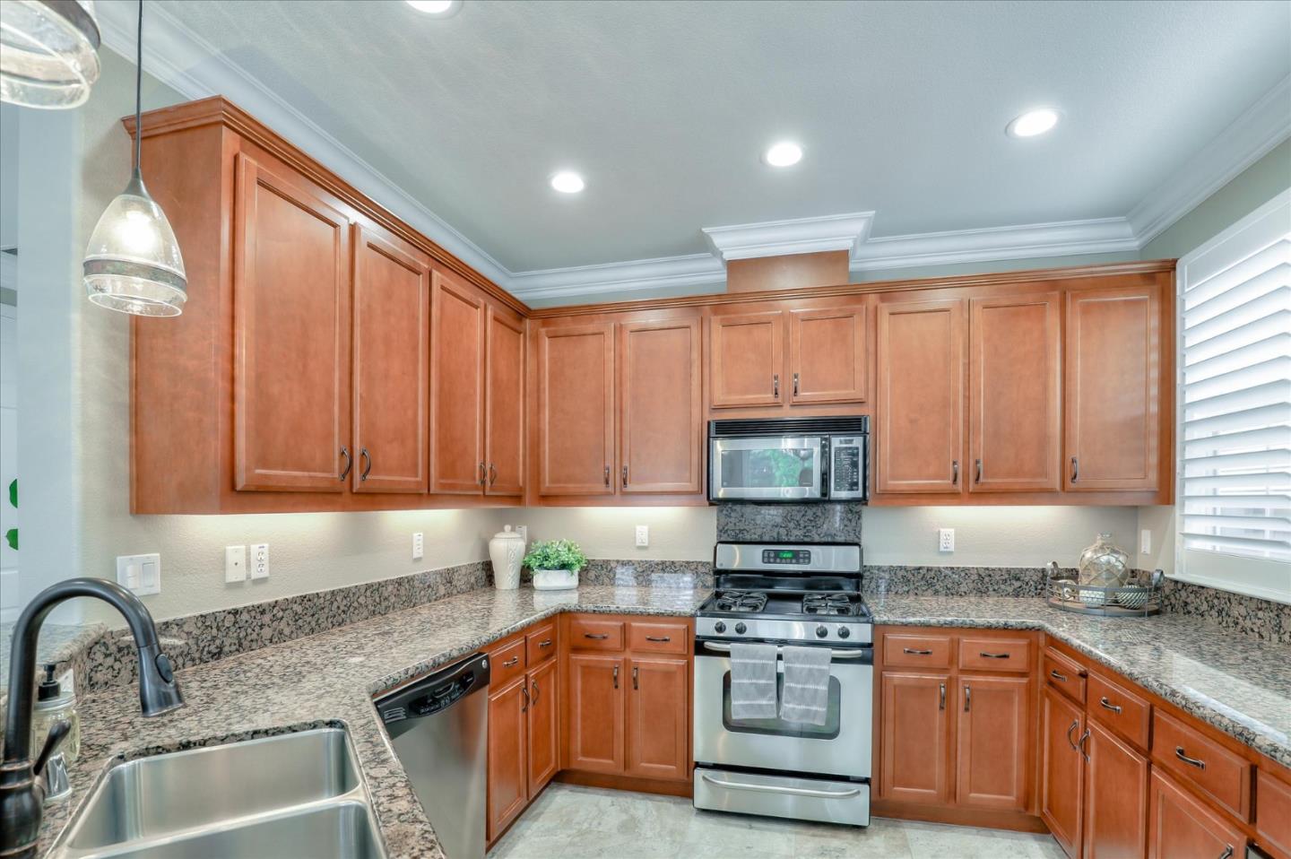 7820 Dickens Way Gilroy, CA 95020 - Photo 8 of 27 a kitchen with stainless steel appliances granite countertop a stove a sink and a microwave