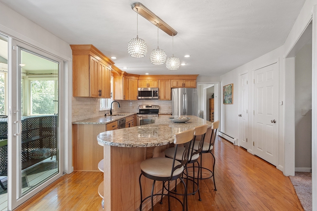 3 Sycamore Drive Rutland, MA 01543 - Photo 8 of 42 a kitchen with granite countertop kitchen island a table and chairs in it
