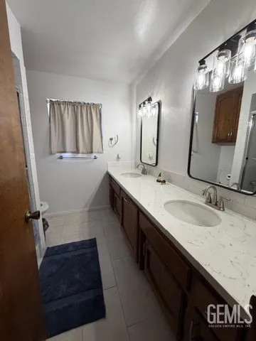 a bathroom with double vanity and a mirror