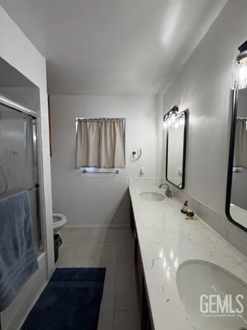 a bathroom with a sink and mirror with toilet