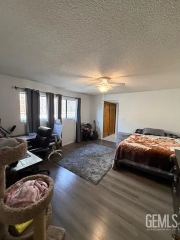 a spacious bedroom with a bed and wooden floor