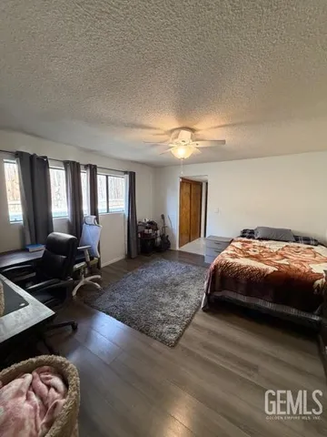 a spacious bedroom with a bed and wooden floor