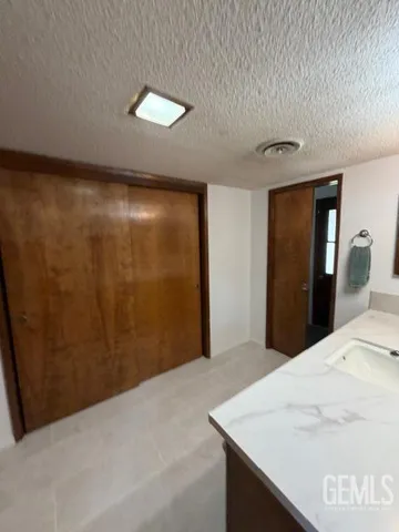 a view of a hallway with wooden floor and a cabinet
