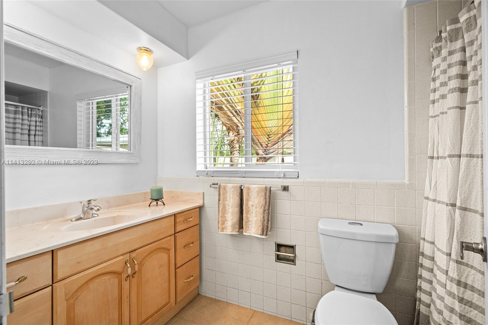 1260 Southwest 9th Street Boca Raton, FL 33486 - Photo 24 of 40 a bathroom with a sink toilet and mirror