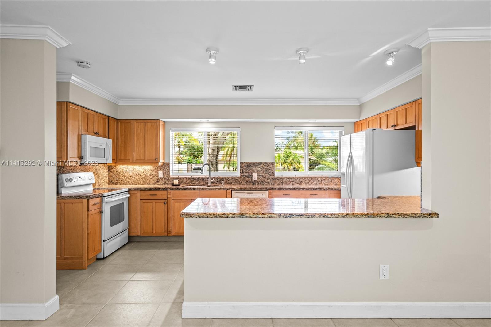 1260 Southwest 9th Street Boca Raton, FL 33486 - Photo 6 of 40 a large kitchen with stainless steel appliances granite countertop a sink and a stove