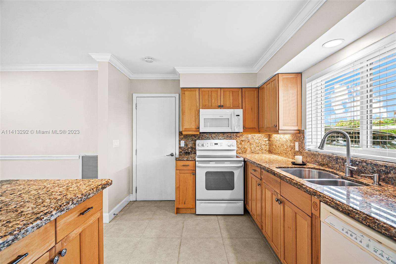 1260 Southwest 9th Street Boca Raton, FL 33486 - Photo 8 of 40 a kitchen with stainless steel appliances granite countertop a sink stove and refrigerator