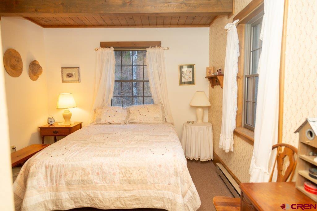 231 Forest Road Creede, CO 81130 - Photo 11 of 31 a spacious bedroom with a bed and wooden floor