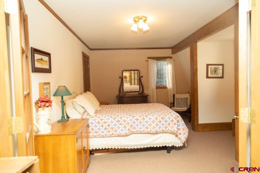 231 Forest Road Creede, CO 81130 - Photo 14 of 31 a bedroom with a bed and wooden floor