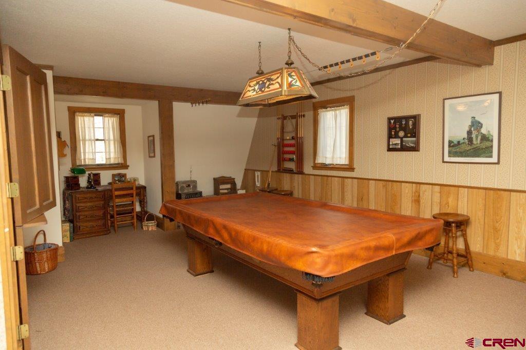 231 Forest Road Creede, CO 81130 - Photo 18 of 31 a bedroom with a bed and a chandelier