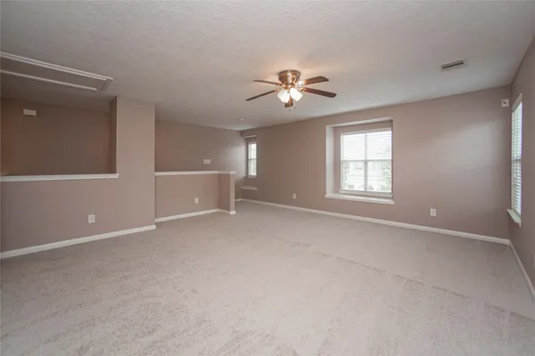 a view of an empty room with a ceiling fan