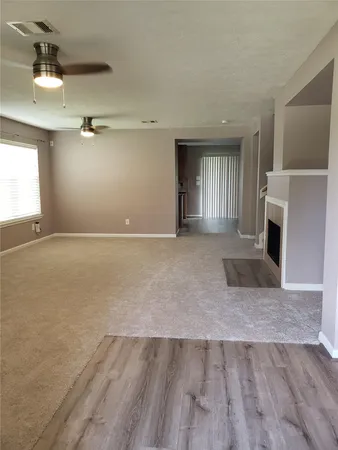 an empty room with windows and fireplace