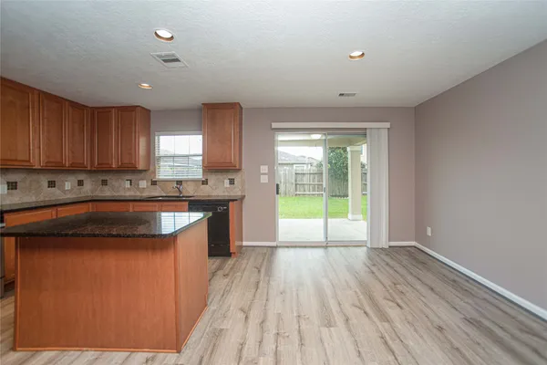 a kitchen with granite countertop a stove a sink and a microwave