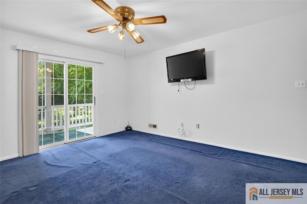 40C Rutland Lane, Unit 40B Monroe Township, NJ 08831 - Photo 22 of 37 en empty room with windows and flat screen tv