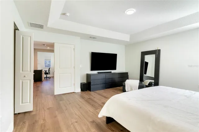 a bedroom with a bed lamp and a large window