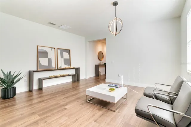 a kitchen with stainless steel appliances granite countertop a stove a refrigerator a kitchen island a dining table and chairs