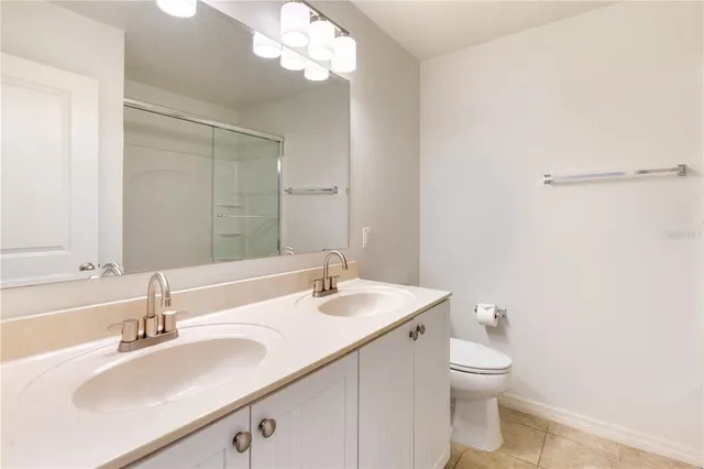 a bathroom with a sink a toilet and a large mirror