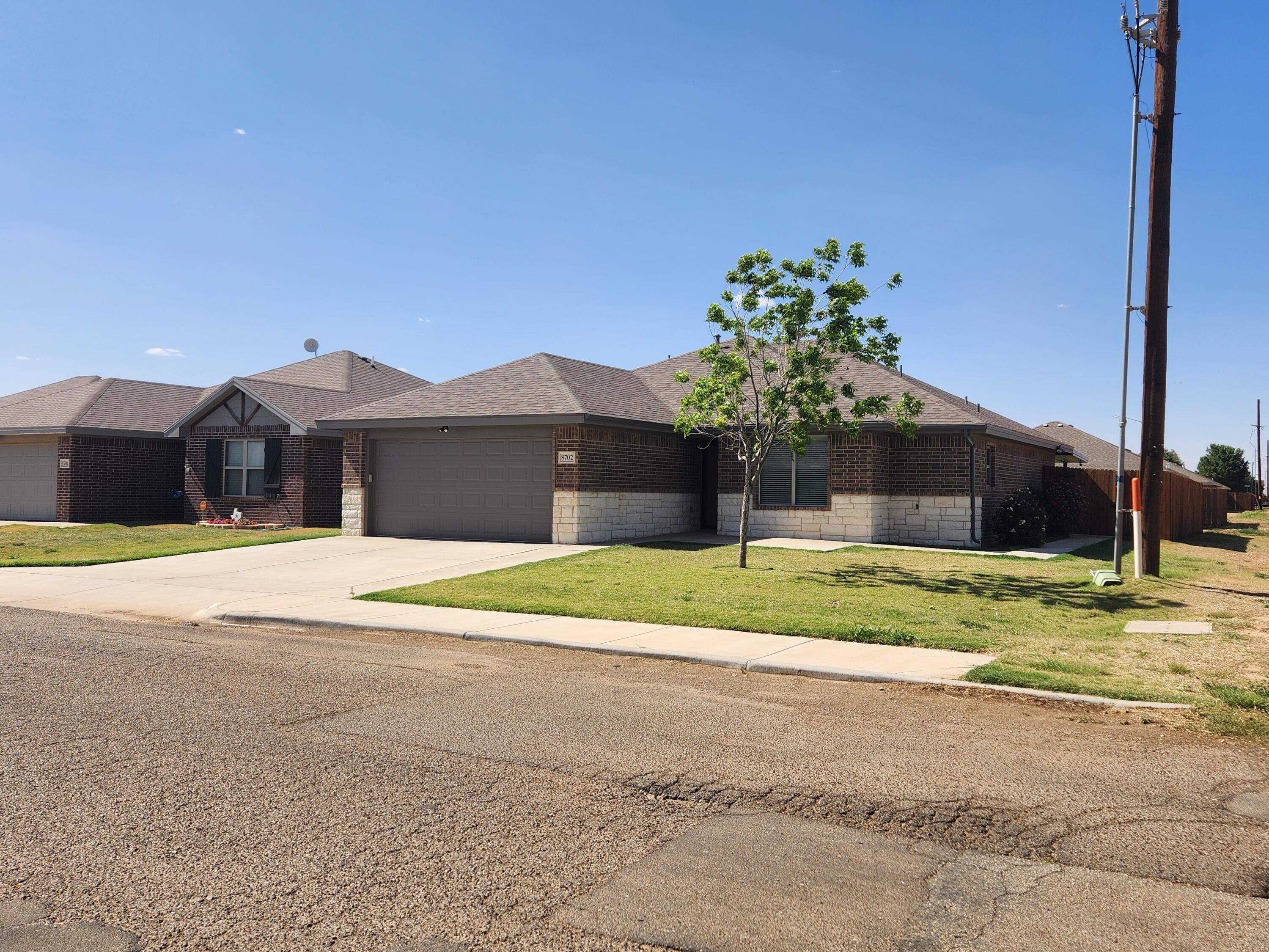8702 13th Street Lubbock, TX 79416 - Photo 1 of 25 a front view of a house with a yard