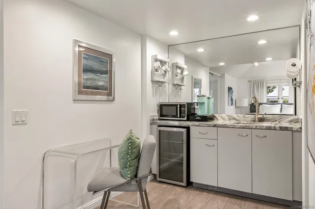 a kitchen with granite countertop white cabinets and chairs