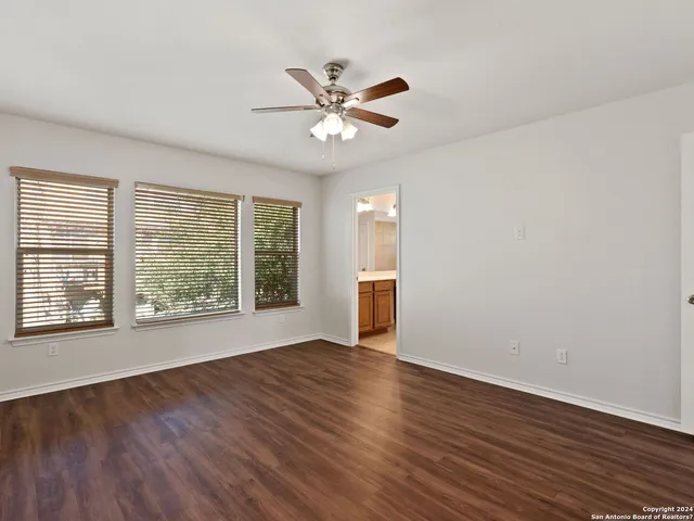 an empty room with a window and wooden floor