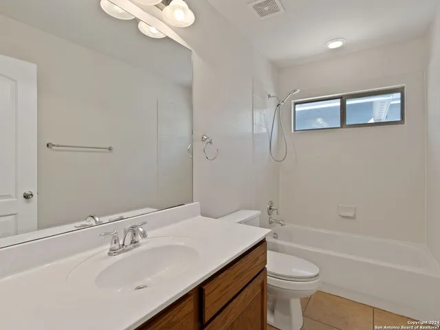 a view of a yard with wooden fence and a large tree