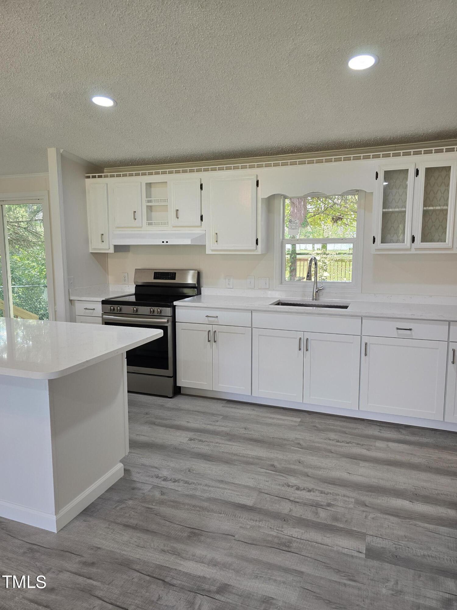 1096 Worthville Road Randleman, NC 27317 - Photo 4 of 20 a kitchen with stainless steel appliances granite countertop a stove a sink and white cabinets