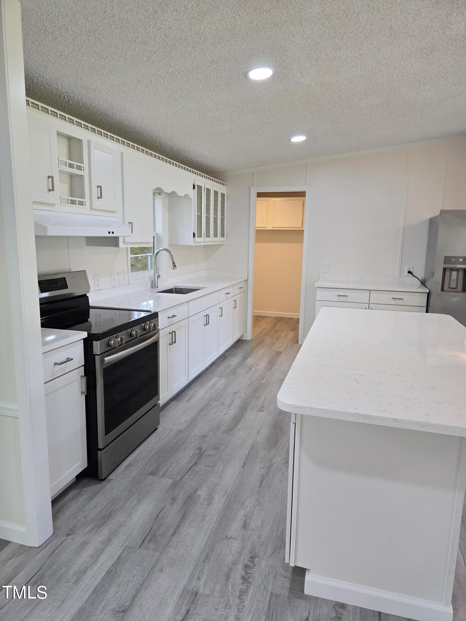 1096 Worthville Road Randleman, NC 27317 - Photo 5 of 20 a kitchen with granite countertop white cabinets and white appliances