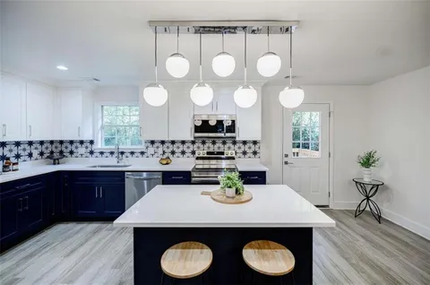 a kitchen with stainless steel appliances a refrigerator and a stove top oven