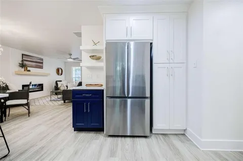 a kitchen with kitchen island wooden floors appliances and cabinets