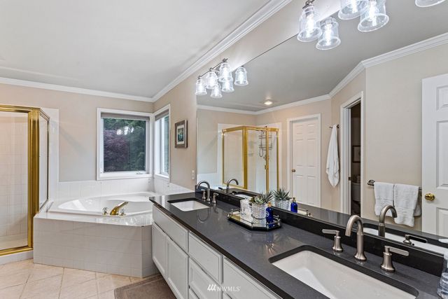 a bathroom with a tub double sink and a mirror