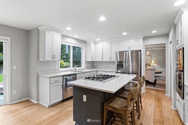 a kitchen with a stove a refrigerator and a dining table