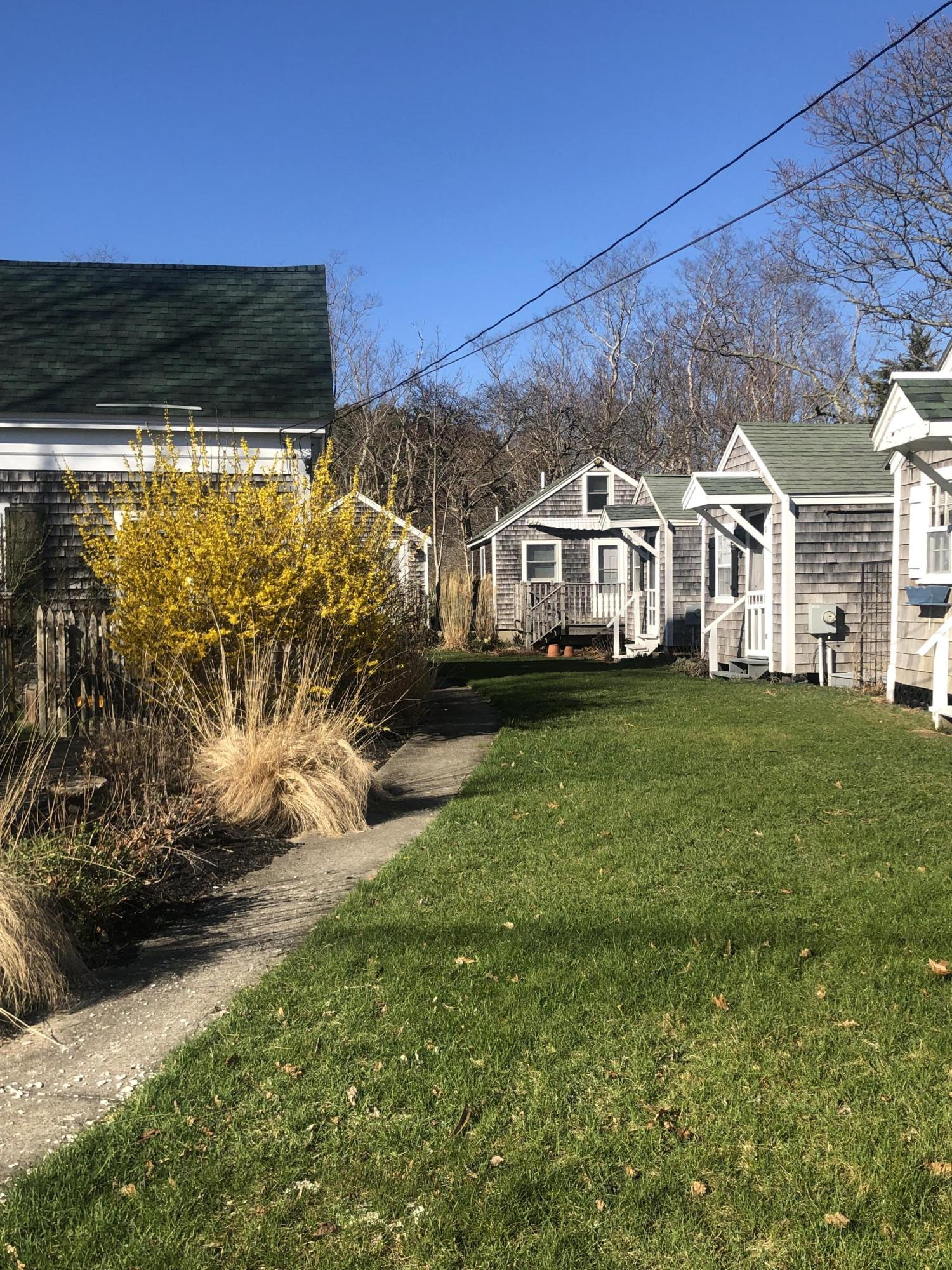 17 Shore Road, Unit 7 Truro, MA 02666 - Photo 6 of 11 a front view of a house with a yard table and chairs