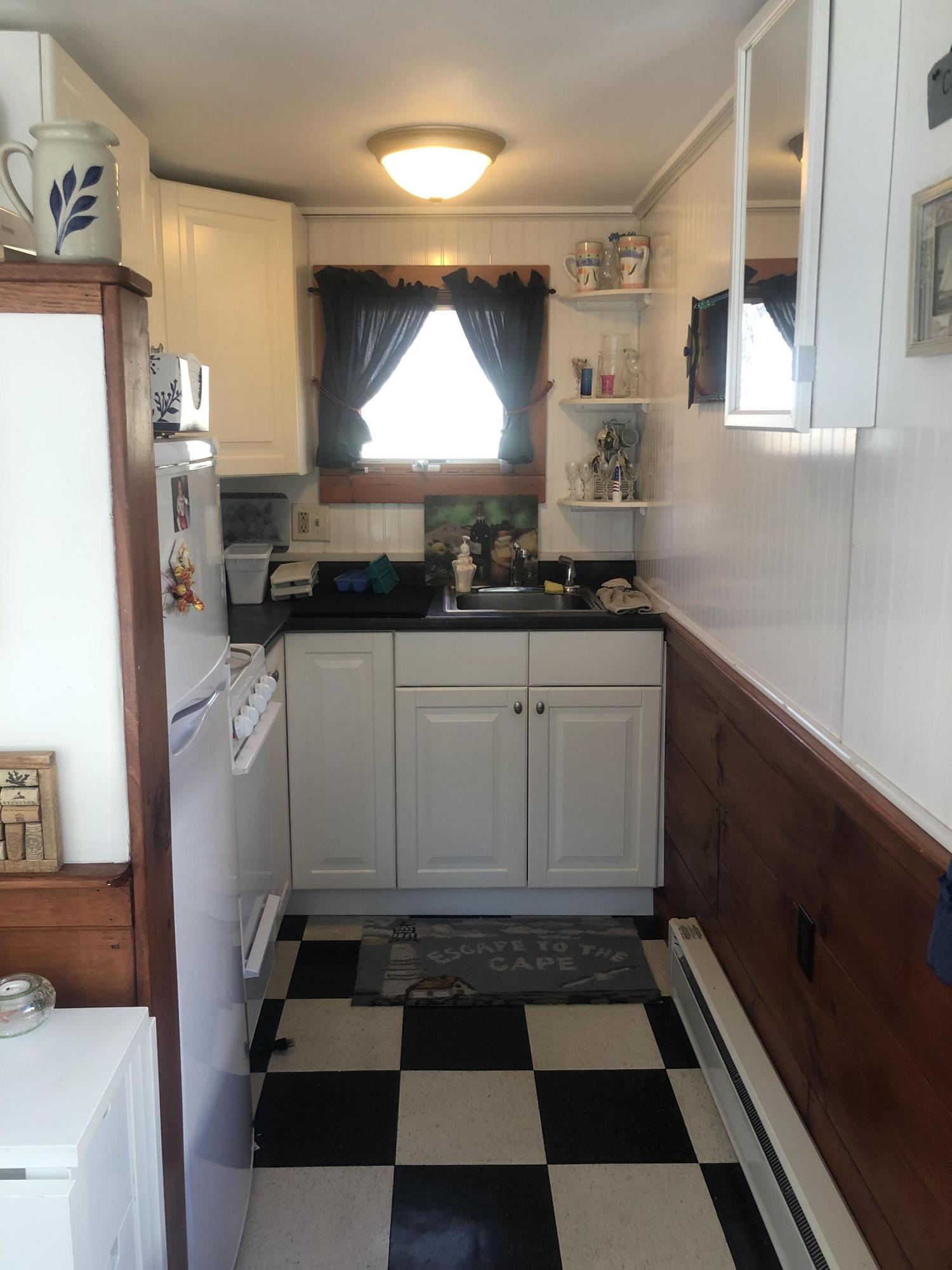 17 Shore Road, Unit 7 Truro, MA 02666 - Photo 8 of 11 a kitchen with a sink a stove and cabinets