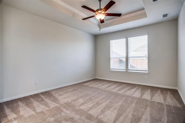 an empty room with windows and fan