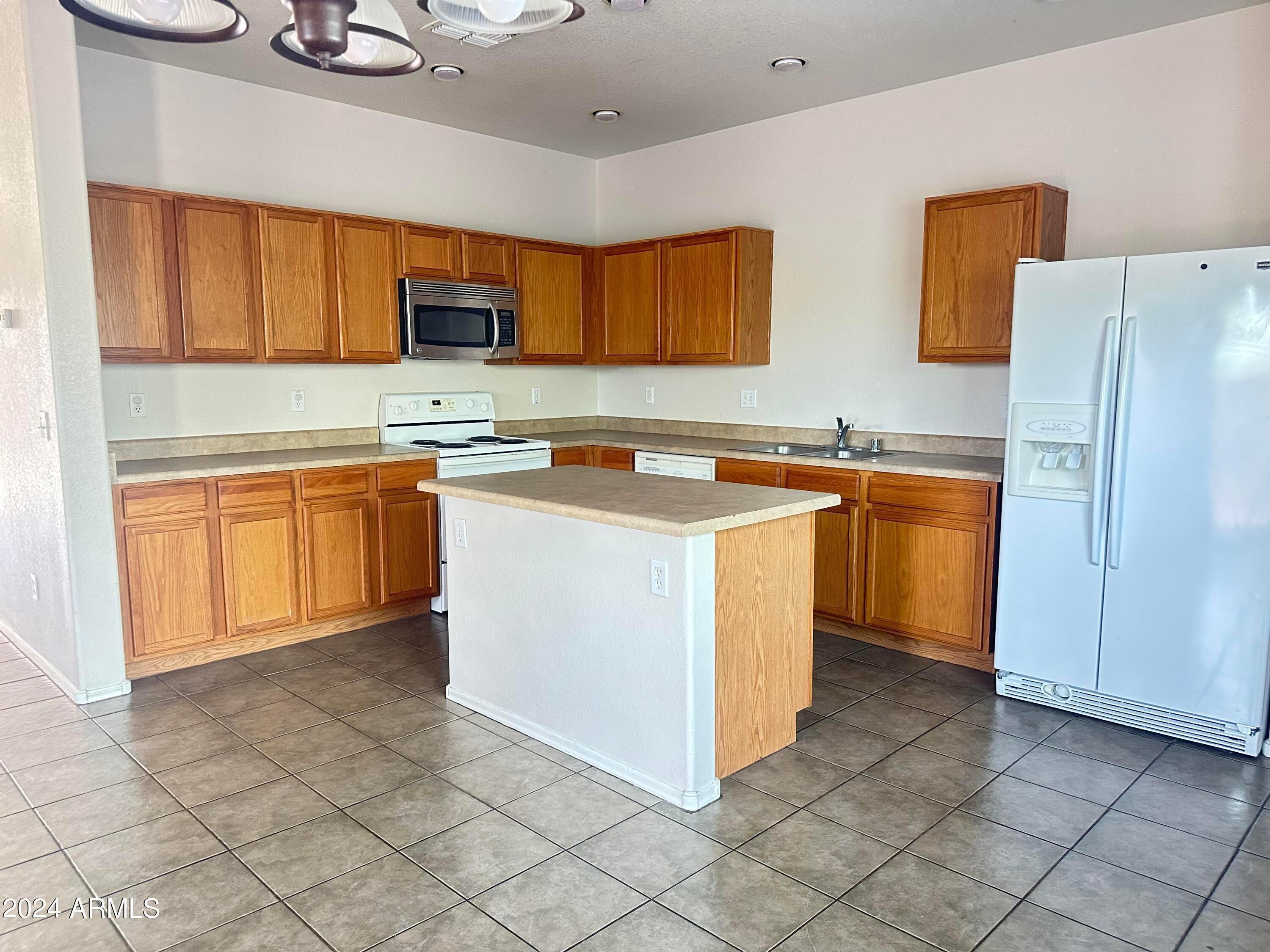 a kitchen with stainless steel appliances granite countertop a stove a sink dishwasher and a refrigerator