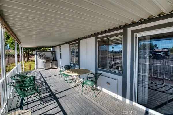 a view of a porch with wooden floor and furniture