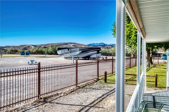 a view of a patio with couches and table and chairs with wooden floor and fence