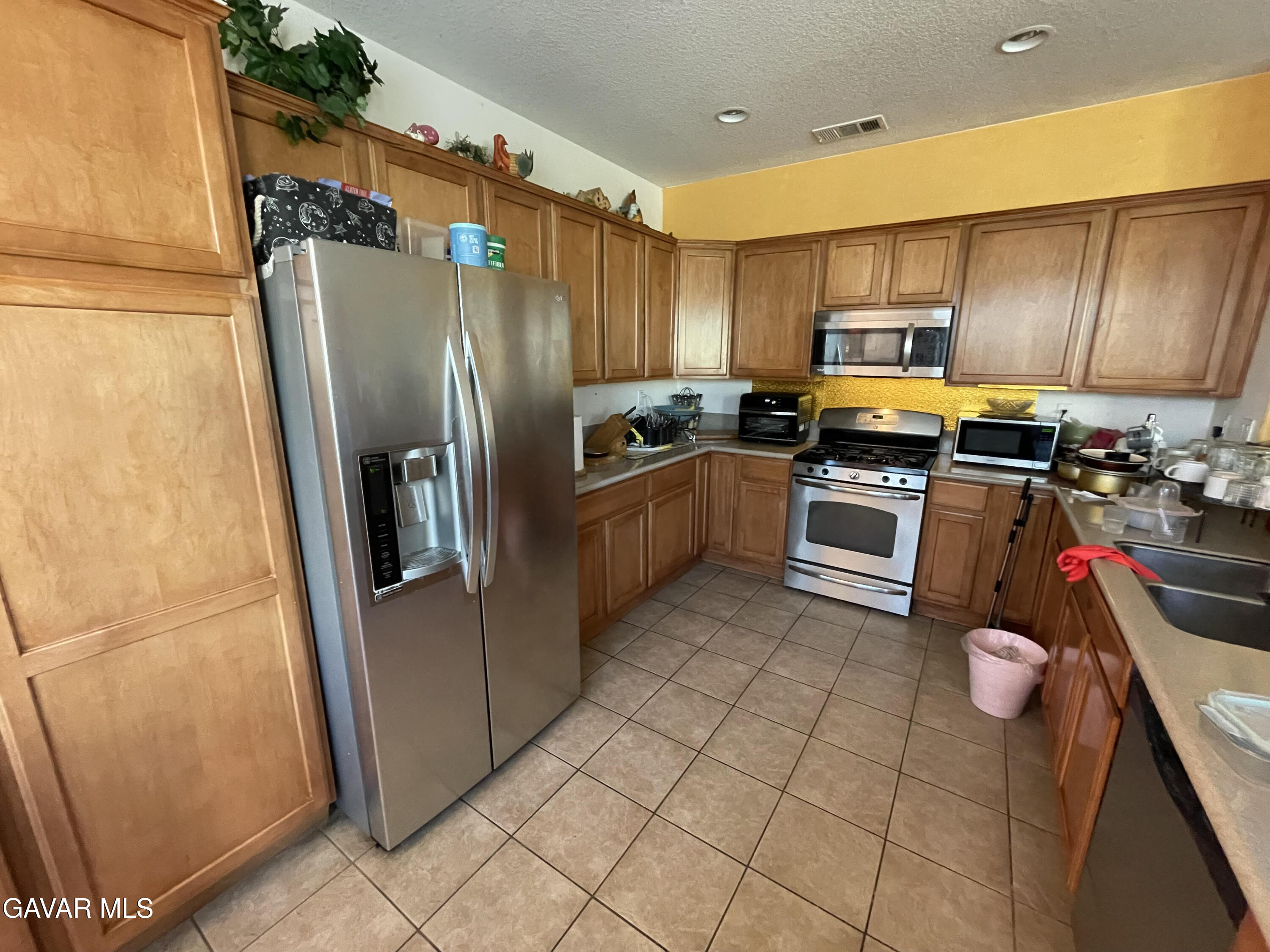 3303 Arious Way Lancaster, CA 93536 - Photo 40 of 43 a kitchen with stainless steel appliances granite countertop a refrigerator a stove top oven and sink