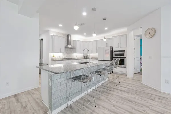 a kitchen with granite countertop white cabinets and stainless steel appliances