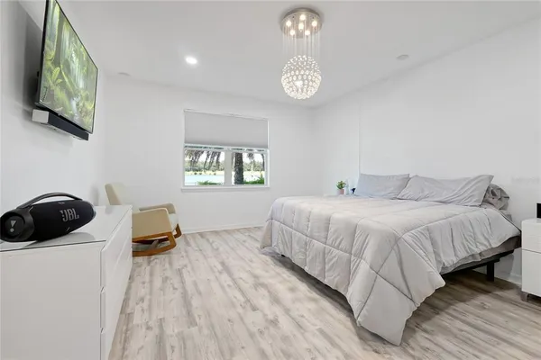 a large white kitchen with a sink and dishwasher with white cabinets