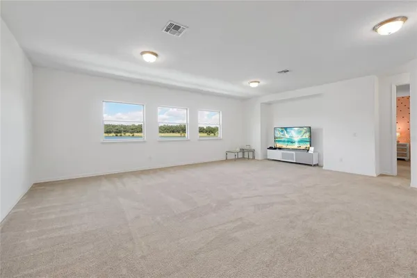 a bed sitting in a room next to a lamp