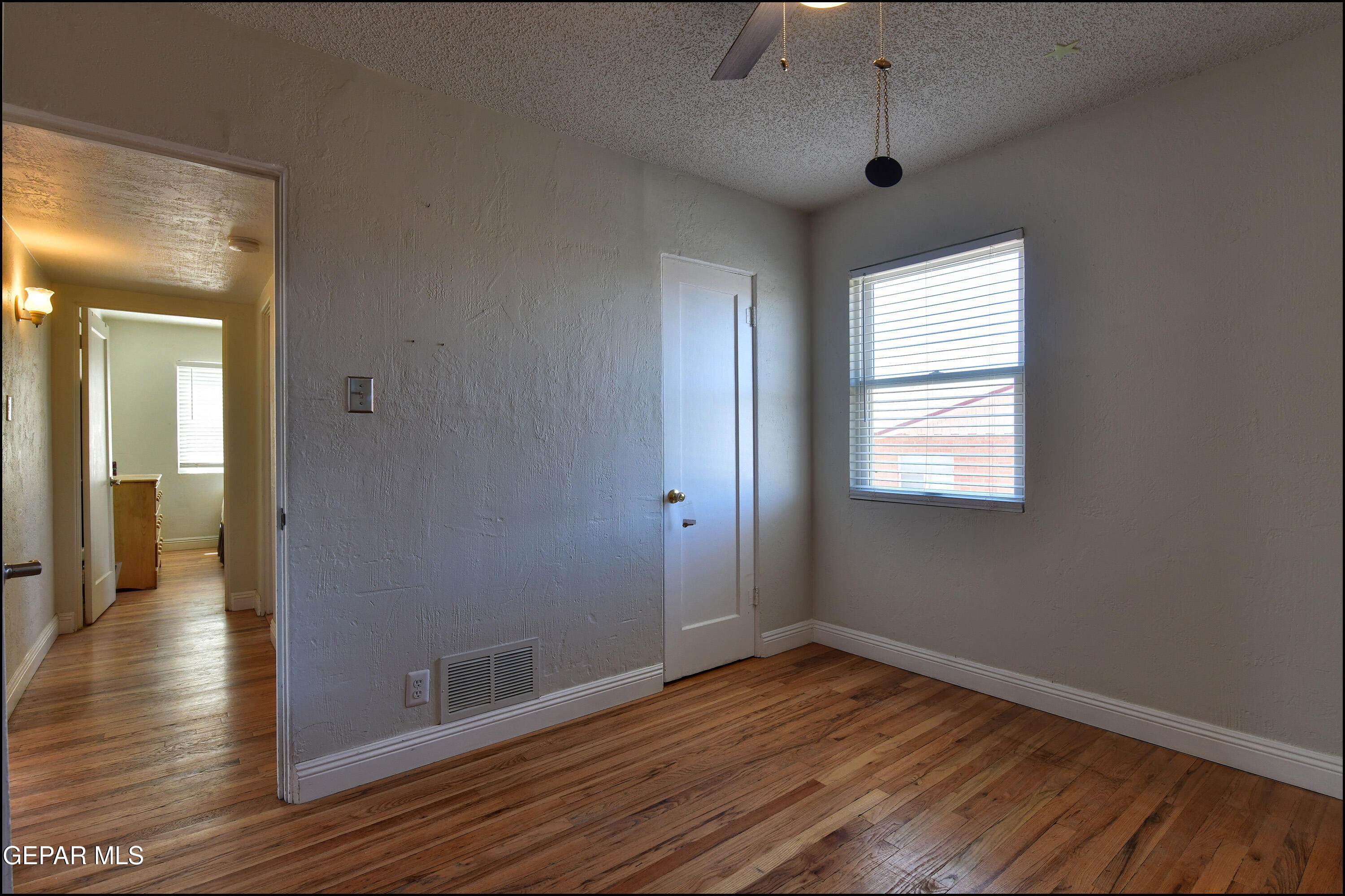 5107 Raymond Jays Road El Paso, TX 79903 - Photo 15 of 35 a view of an empty room with wooden floor and a window
