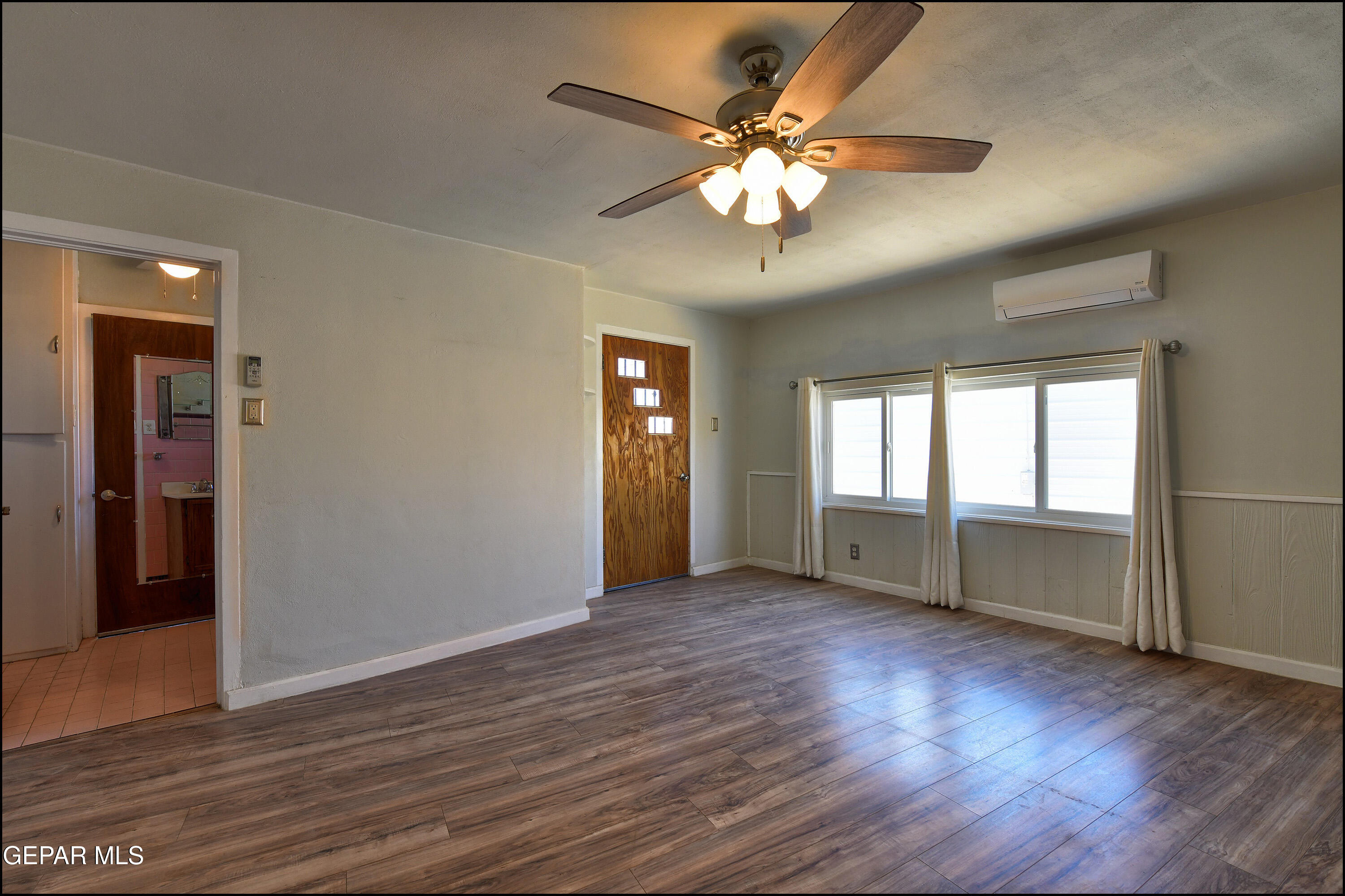 5107 Raymond Jays Road El Paso, TX 79903 - Photo 19 of 35 an empty room with wooden floor and windows