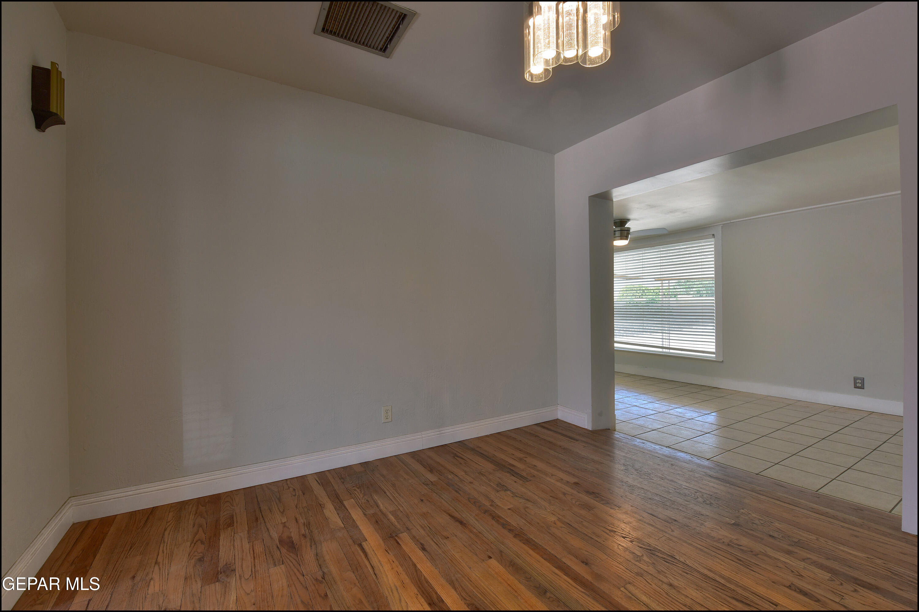 5107 Raymond Jays Road El Paso, TX 79903 - Photo 7 of 35 an empty room with wooden floor and windows
