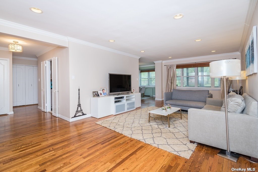 180 South Middle Neck Road, Unit 2H Great Neck, NY 11021 - Photo 1 of 1 a living room with furniture wooden floor and a flat screen tv